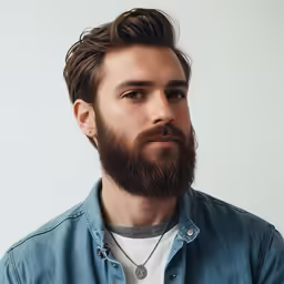 a man wearing a denim shirt with a beard and a freckle around his neck