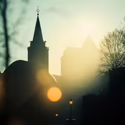 the sun is seen rising over some large buildings
