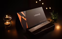 a close up of a lit candle and a business card
