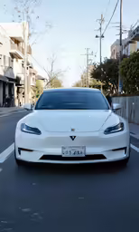 the white tesla - based car is sitting on the street
