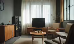 a living room with a television and some chairs
