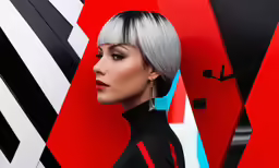 a woman with bright, black and white makeup poses near a red background