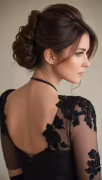a woman in a black dress wearing a high bun with hair clipping