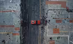 a red car sitting on top of a parking lot