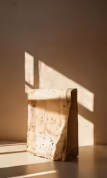 the tan concrete wall holds an empty square with a shadow