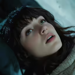 a beautiful young woman laying on top of a bed