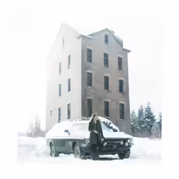 a woman standing next to a car on a snow covered ground