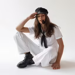 a woman sits cross legged wearing white