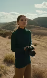 a woman with a camera in a desert