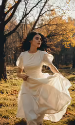 a woman in white dress running across grass