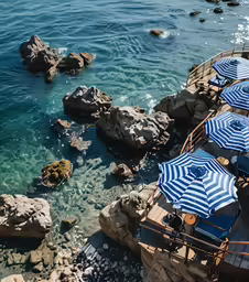 a group of umbrellas sitting on top of rocks next to the ocean