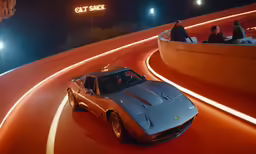 a silver sports car driving down a curved road