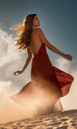 the beautiful girl in a red dress walking along a beach