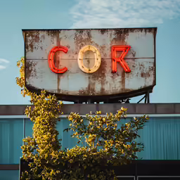 an old neon sign sitting on top of a building