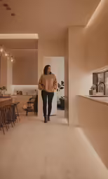 woman walking in room between tables and bar stools
