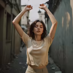 a woman standing on a road with her arms raised