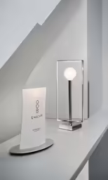 the modern light stands on a shelf next to an electronic device