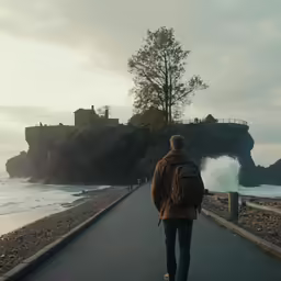 the man walks alone down the path towards a castle on the shore