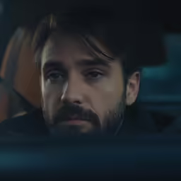 a man is looking in the mirror while driving