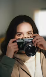 a woman is holding a camera up to her face