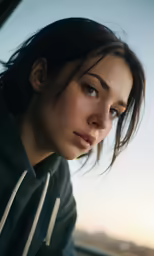 a woman with a hoodie sitting in a vehicle