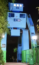 a large blue robot sculpture over looking a building