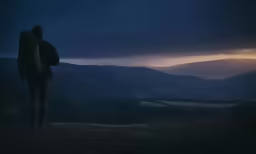 a man standing in the dark overlooking mountains