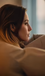 a woman sitting on a couch with a remote in her hand