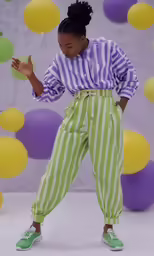 woman wearing a striped top and pants posing for a picture
