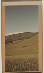 an old photo of a farm with a barn on the other side of a field
