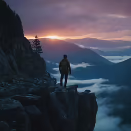a man standing on the edge of a cliff during a sunset