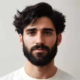 a young man wearing white with a large beard