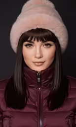 a young woman with long hair wears a fur hat