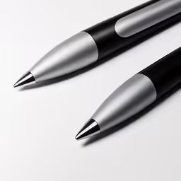 a couple of black pen laying next to each other