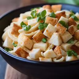 a bowl full of cheese and vegetables on a wooden surface