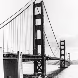 a person sitting on a boat by the side of a bridge