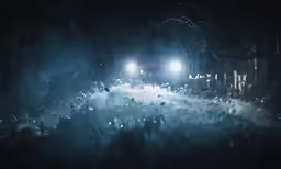 a large crowd stands outside with several lights in the air