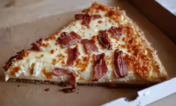 a slice of pizza sitting in a pizza box