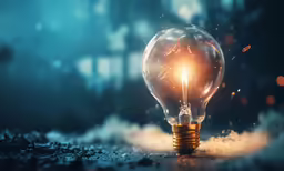 an orange light bulb sitting on top of a pile of smoke