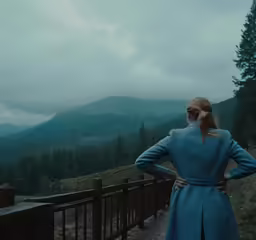 a woman looking at the mountain from a walkway