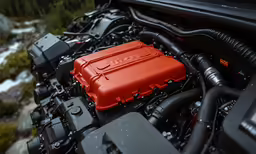 the engine compartment of a sports car with red engine cover