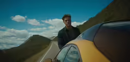 man standing on road looking at camera from driver side