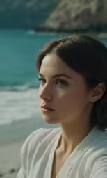 woman sitting on beach looking at the sea
