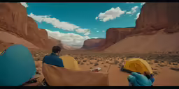 two people sit at camps near the mountains