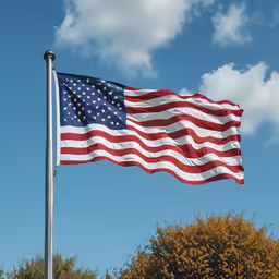an american flag on a flag pole against the blue sky