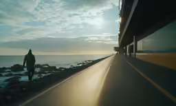 a person walking by the water and a building