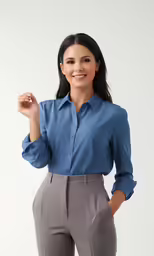 a woman wearing slacks and blue shirt smiling
