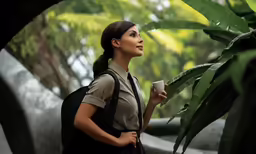 a beautiful young lady with a backpack on holding a cup in her hand