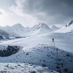 a lone snowboarder walking up the side of a mountain