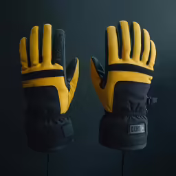 a pair of black and yellow gloves are set on a black surface